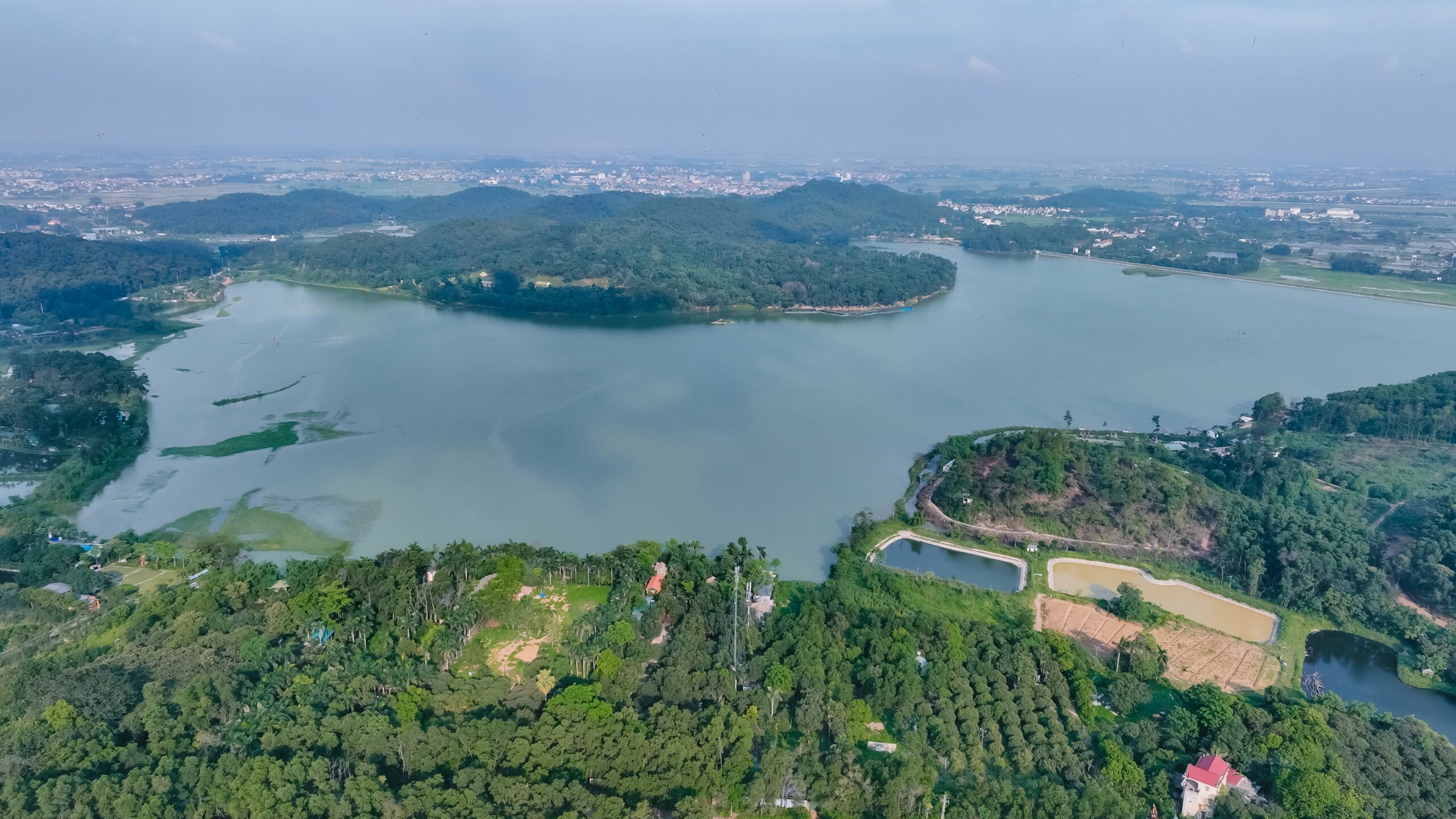 Góc nhìn từ trên cao bao quát hồ nước rộng lớn và núi rừng thiên nhiên bao quanh Soc Village