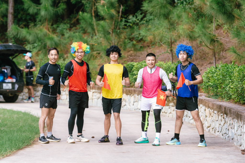 Nhóm nam thanh niên đội tóc giả màu sắc tạo dáng chụp ảnh teambuilding tại Sóc Village