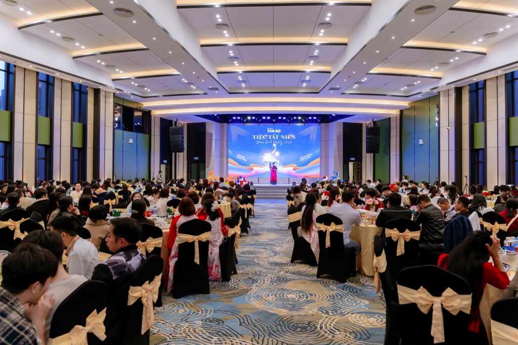 Tiệc tất niên doanh nghiệp tổ chức tại Ballroom 1 Sóc Village với sân khấu và bàn tiệc