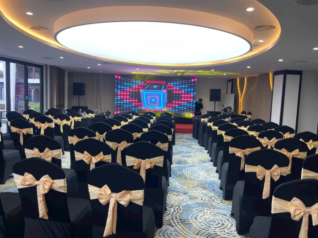 Ballroom 2 Sóc Village setup phòng hội nghị với ghế sân khấu, bàn đại biểu và màn hình LED