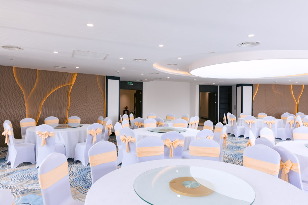 Không gian Ballroom 2 Sóc Village được setup bàn tròn và ghế nơ vàng cho tiệc hoặc sự kiện